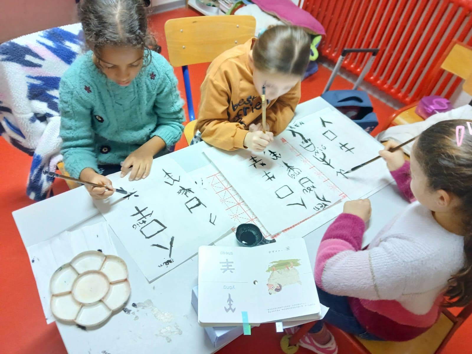 Chinese calligraphy workshop: pupils trace characters with a brush.