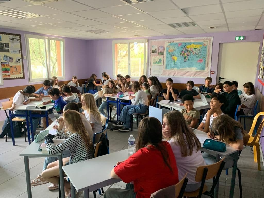 Une classe de collège au travail dans une salle lumineuse.