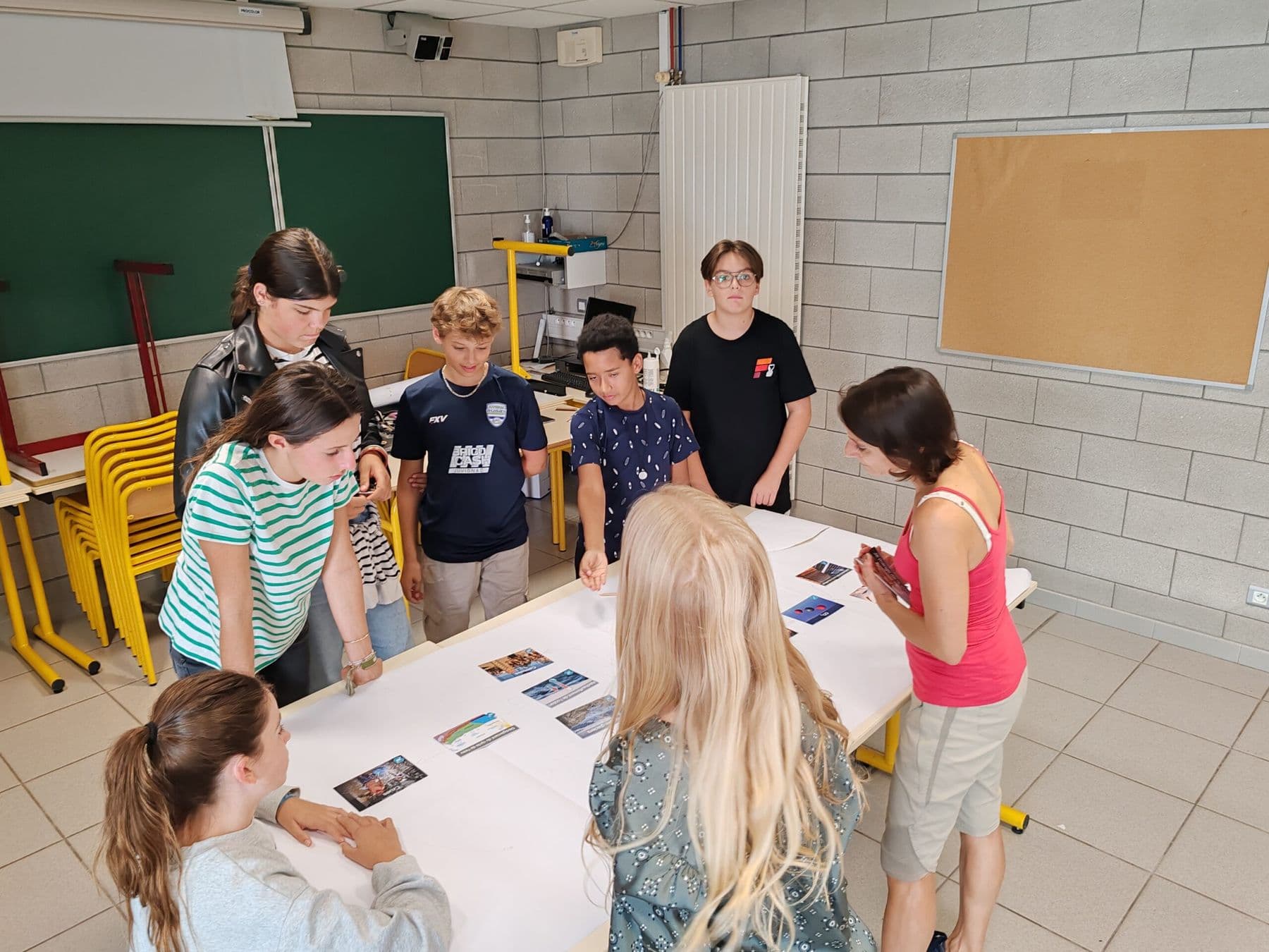 Climate Fresk workshop: middle school pupils arrange cards around a table.