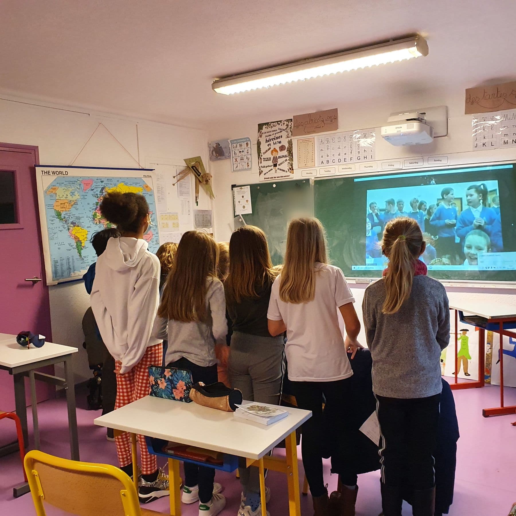 Pupils on a video call with a class of English pen pals.