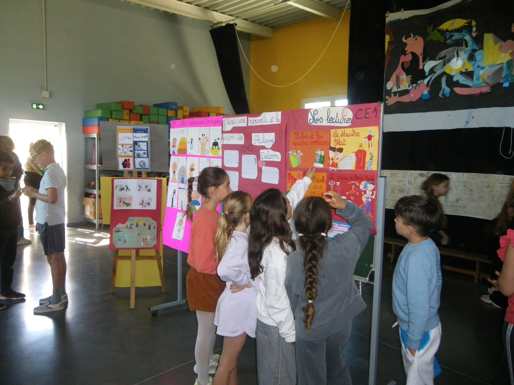 Des élèves découvrent une exposition sur les lectures d'une classe de primaire.