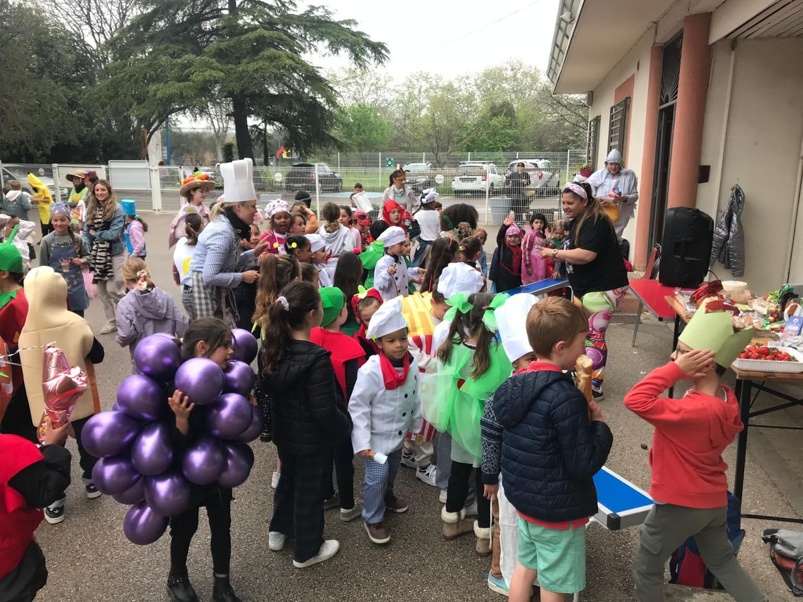Carnival in the playground: pupils dressed as fruit, vegetables and chefs.