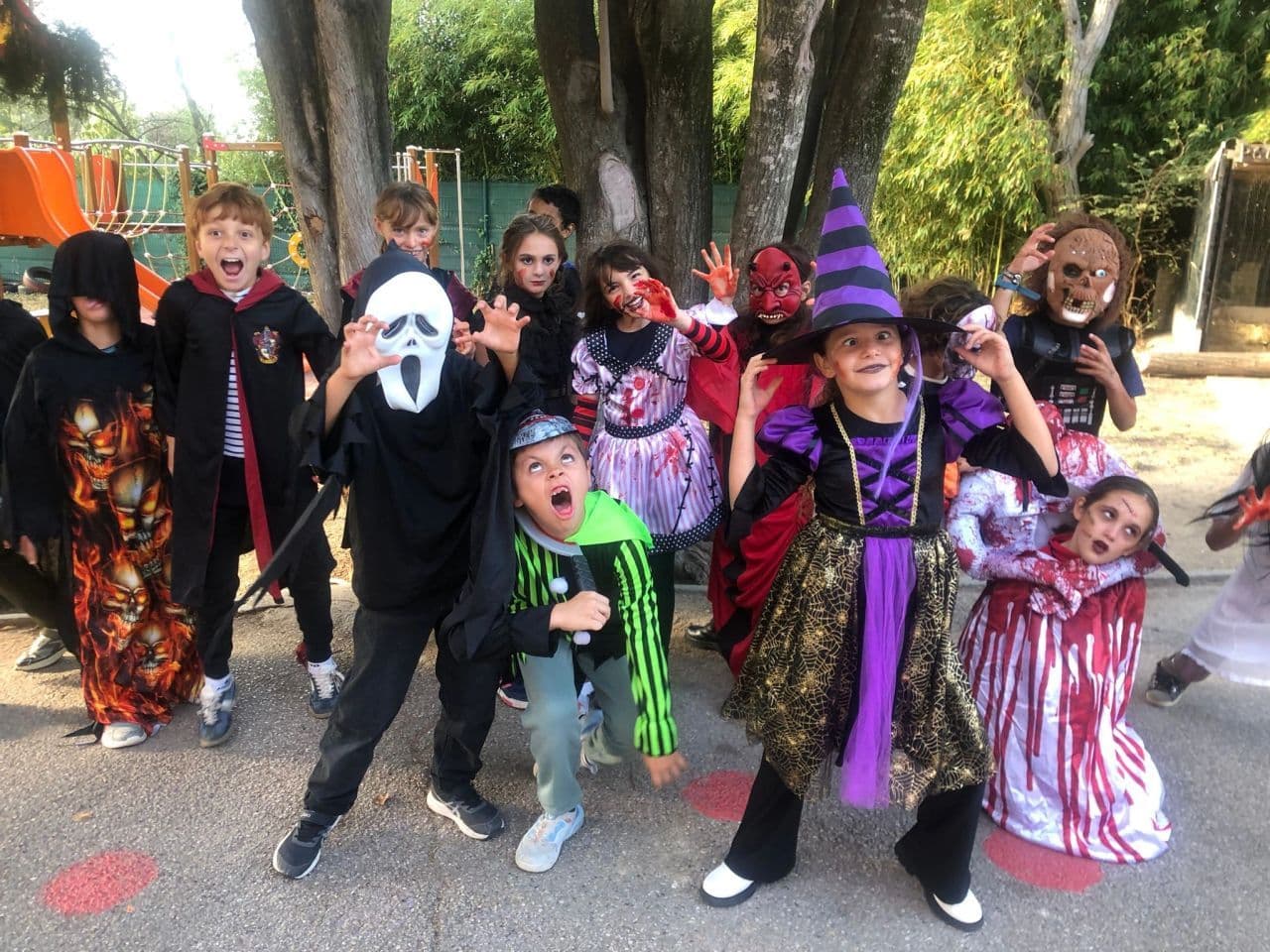 Halloween: a group of pupils in costume poses in the playground.