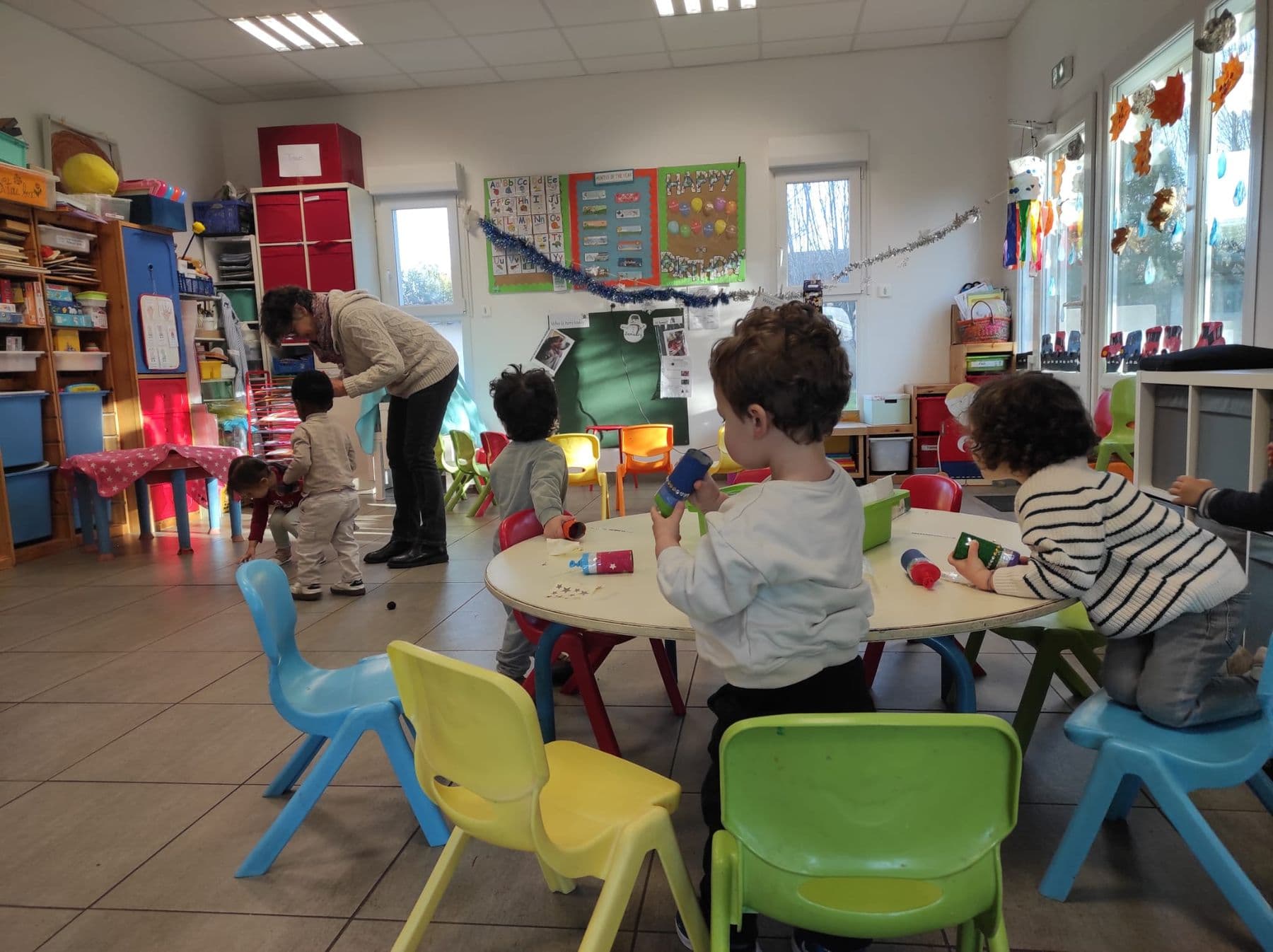 Une classe de maternelle lumineuse, avec ses petites chaises de toutes les couleurs.