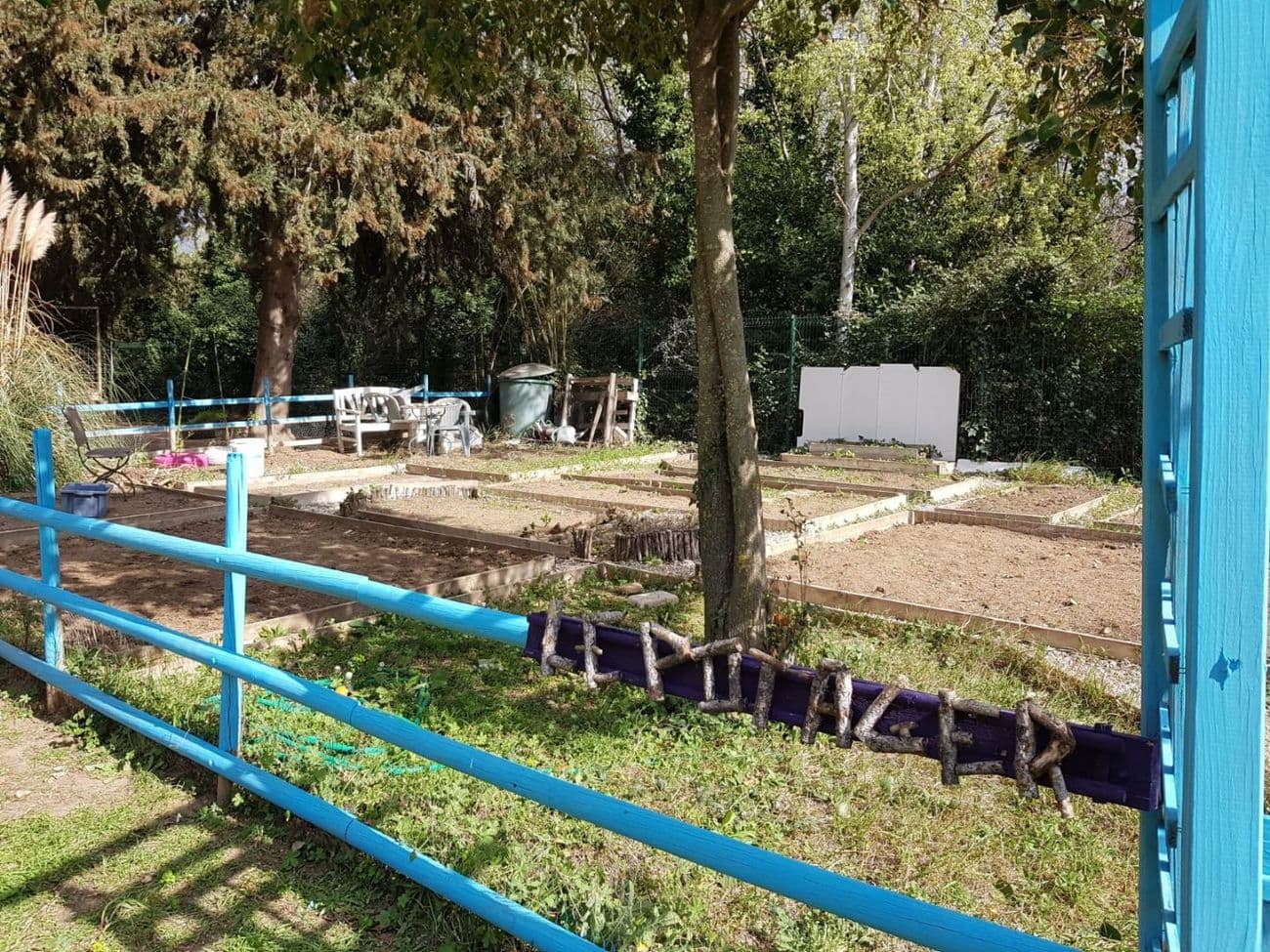 Le potager de l'école, derrière sa barrière bleue.