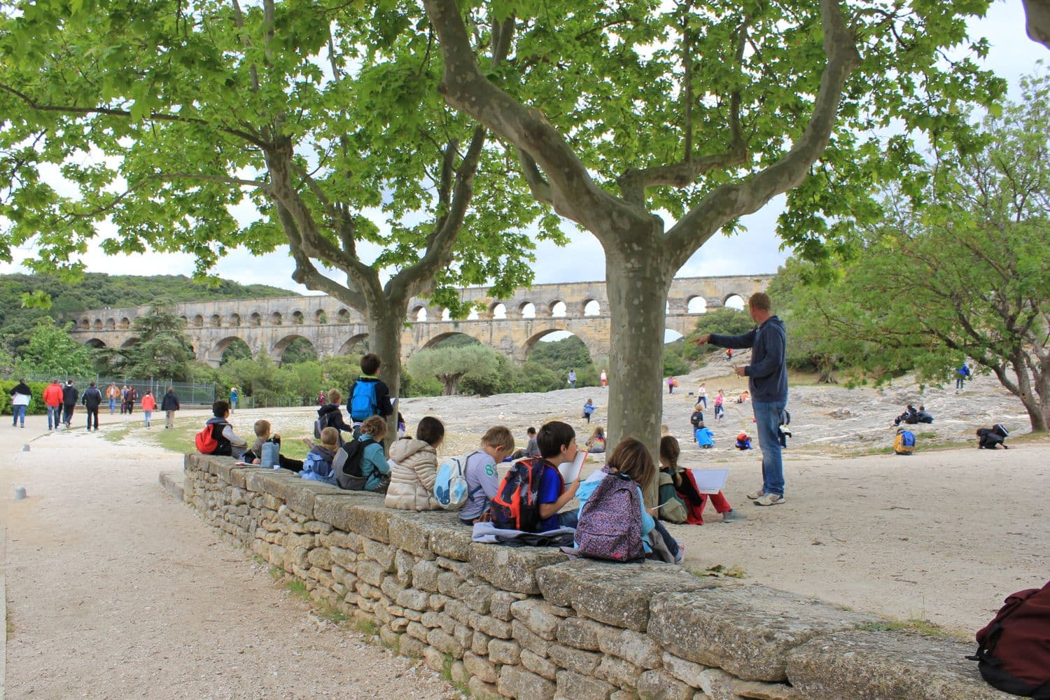 A break under the plane trees, with the Pont du Gard in the background.
